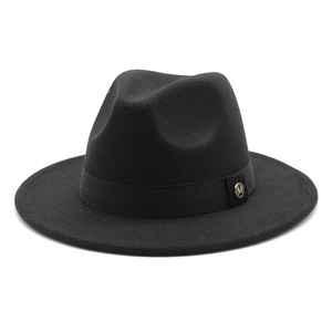 Close-up of black fedora wool hat featuring a satin ribbon and golden metal M logo