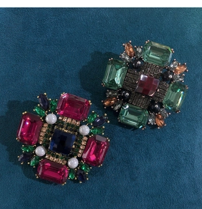Detail of vintage geometric brooches with colorful rhinestones and imitation pearls