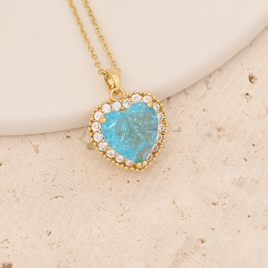 Golden necklace featuring a faceted blue heart pendant surrounded by white crystals