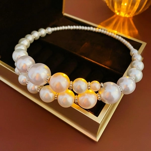 Macro detail of faux pearl necklace with gold spacers in a premium velvet jewelry box