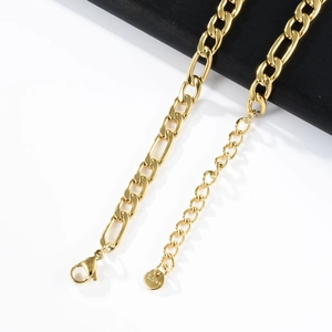 Close-up of golden stainless steel Figaro chain with lobster clasp and S.Steel tag