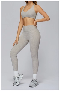 Close-up of a light heather grey V-neck racerback sports bra and high-waist leggings set