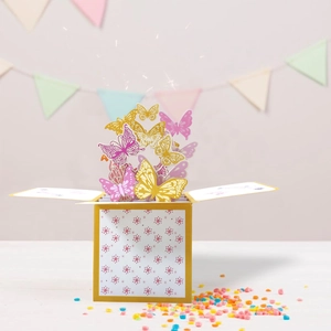 Detail of 3D pop-up gift box card with vibrant colorful paper butterflies and confetti