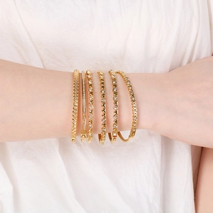Vista dettagliata del set di bracciali in oro e acciaio con cuori e cristalli lucenti