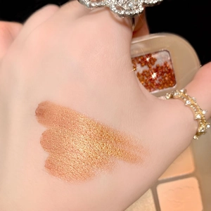 20-color eyeshadow palette swatch showing shimmering golden brown powder on skin