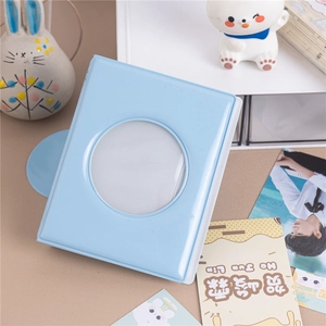 Blue 3-inch photo album with a heart-shaped window displayed on a desk with decor
