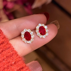Macro shot showing the size of 18K gold plated oval ruby earrings with zircon halo