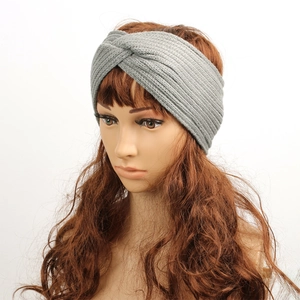 Detail of grey knitted winter headband with a crossover twist design and warm fleece lining