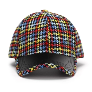Detail of colorful houndstooth fabric with premium black leather brim on baseball cap