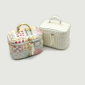 Detailed shot of fabric makeup bags with patchwork and beige floral patterns and zippers