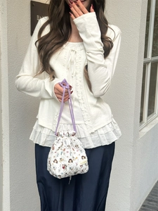 Detailed close-up view of white quilted cartoon drawstring storage bag held by model