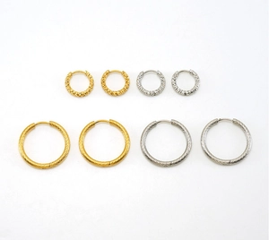 Detailed view of textured gold and silver hoop earrings with hammered surface pattern