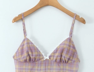 Detail of purple plaid camisole with white lace trim and bow on wooden hanger