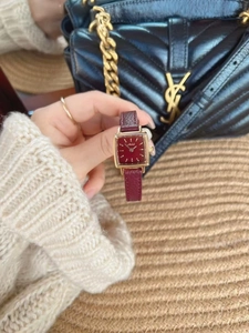 Close-up of a vintage square wine red leather watch with a gold-tone luxury case