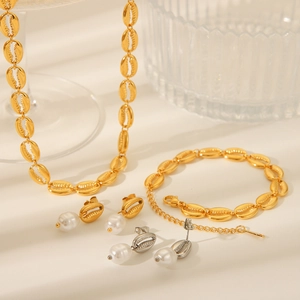 Detail of gold seashell jewelry set including necklace, bracelet and pearl earrings