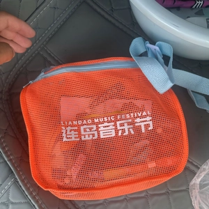 Orangefarbene Strandtasche aus Netzstoff mit blauen Trägern und Aufdruck