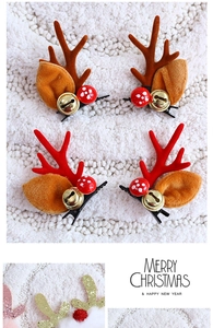 Detail of Christmas reindeer ear hair clips with bells and velvet fabric on plush surface
