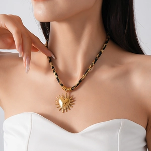 Pendente a cuore solare dorato con cordino leopardato indossato per uno stile elegante