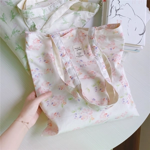 Detailed close-up of floral canvas tote bag featuring pink floral patterns and fabric label