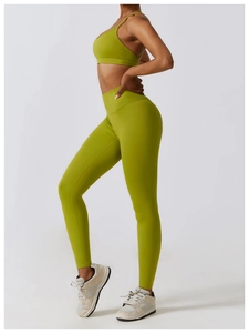 Detail of high-waist yoga leggings and sports bra set in breathable grass green fabric