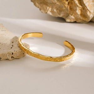 Minimalist golden stainless steel wavy open bangle with irregular hammered texture