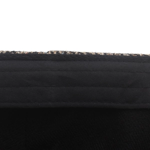 Detailed macro view of cotton plaid newsboy hat texture with black trim and stitching