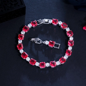 Detailed close-up of a silver-tone bracelet with red square zircons and round white stones