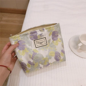 Floral jacquard cosmetic bag detail featuring 'TIME TO PARTY' label and purple flower pattern