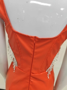 Détail de robe en similicuir orange avec fermeture éclair au dos et franges en strass