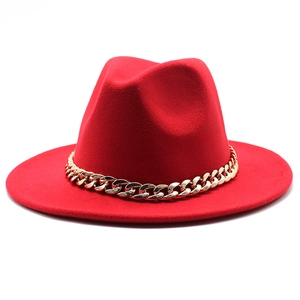 Detail view of red fedora hat featuring a stylish gold metal chain accent and wool texture
