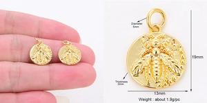 Macro detail and size guide for a small gold bee embossed coin charm pendant for DIY