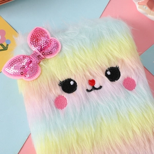 Dettaglio della copertina del taccuino in peluche arcobaleno con fiocco di paillettes rosa
