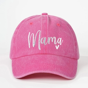 Close-up of pink washed baseball cap featuring white Mama embroidery and small heart