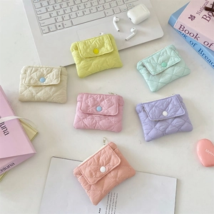 Quilted macaron card holders in six pastel colors arranged on an aesthetic workspace