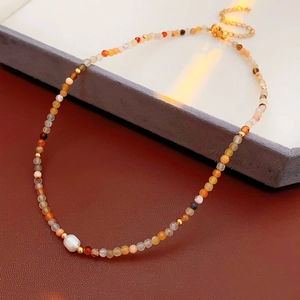 Detailed macro of multi-color beads with a baroque pearl on a titanium steel necklace