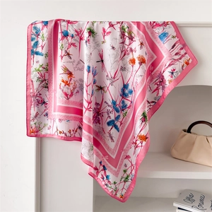 Carré de soie aux motifs marguerites et libellules drapé sur une étagère blanche