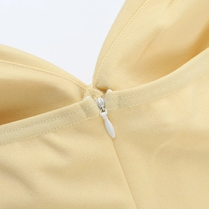 Macro detail of high-quality invisible zipper on a yellow A-line evening dress