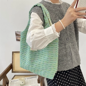 Close-up of vibrant green woven tote bag with colorful stripes and fabric label detail