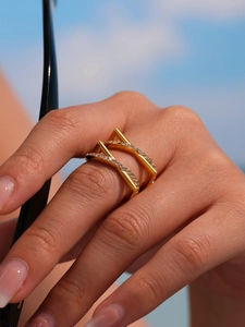Close-up of a double-layer gold ring with paved diamonds and a modern geometric design