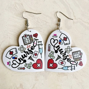 Macro detail of heart-shaped faux leather earrings featuring nurse print on marble background