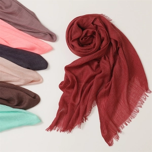 Close-up of soft cotton linen scarves with fringe edges in a variety of vibrant colors