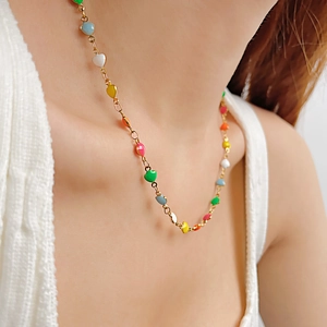 Collier avec pendentifs cœur arc-en-ciel en acier inoxydable doré sur un mannequin