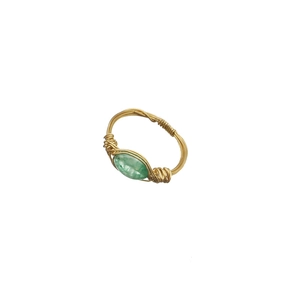 Handcrafted gold wire-wrapped ring featuring an oval green gemstone on a white background