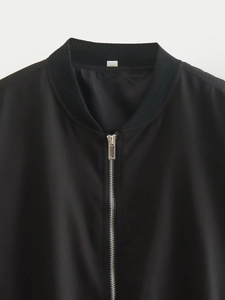 Detail of ribbed collar and metallic zipper on a black casual bomber jacket