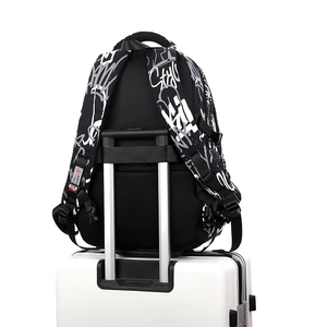 Minimalist black and white graffiti backpack secured on a suitcase handle with back strap
