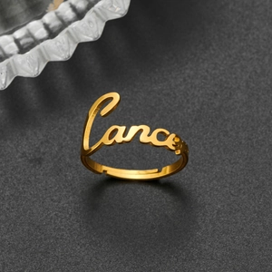 Macro shot of gold-plated Cancer constellation lettering on adjustable stainless steel ring