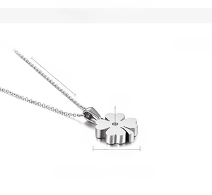 Macro side view of silver titanium steel four leaf clover pendant with cubic zirconia