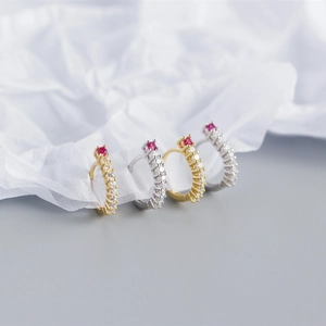 Macro shot of S925 sterling silver huggie earrings with red stones and clear crystals