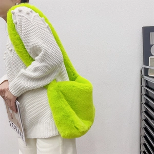 Detail of neon green plush faux fur shoulder bag with soft fluffy texture and moon shape