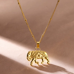 Macro shot of gold-plated elephant pendant necklace with detailed engraved patterns